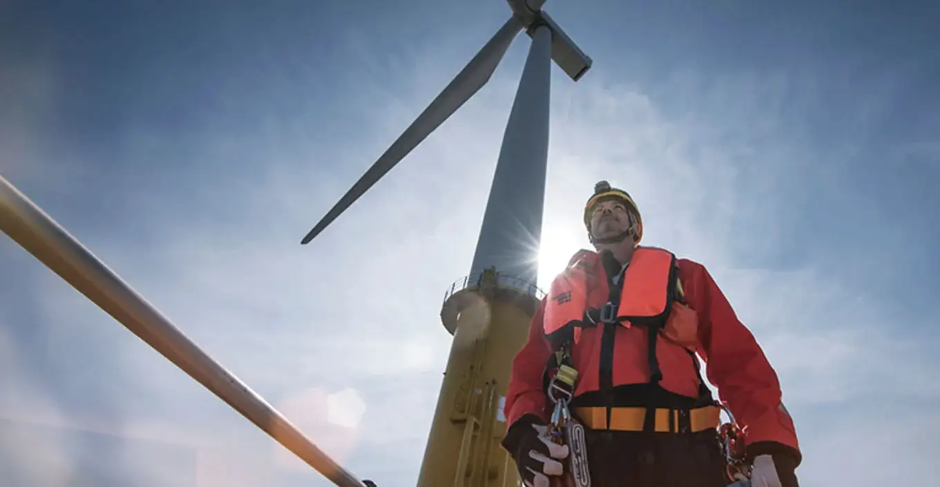 Man standing in front of wind turbine