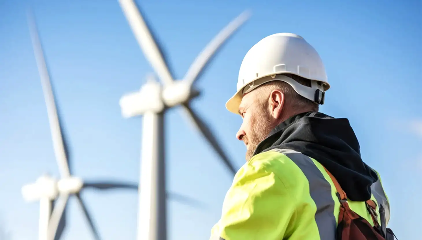 Man standing beside wind turbines
