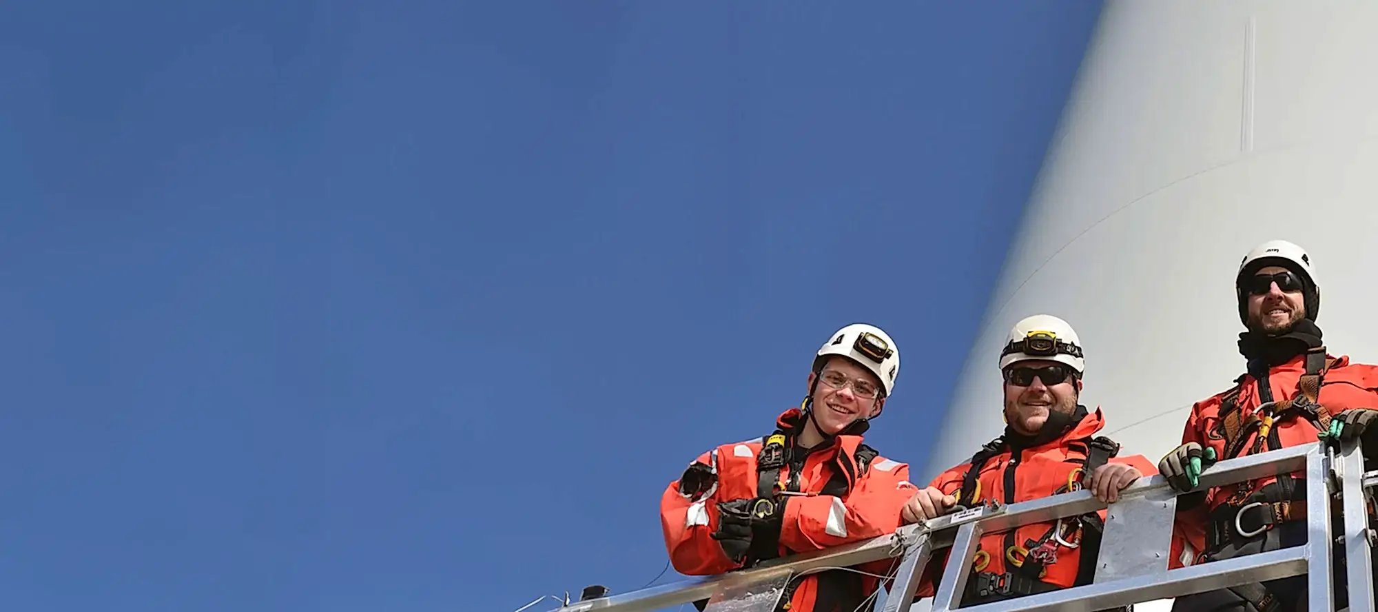 OEG team standing in front of wind turbine